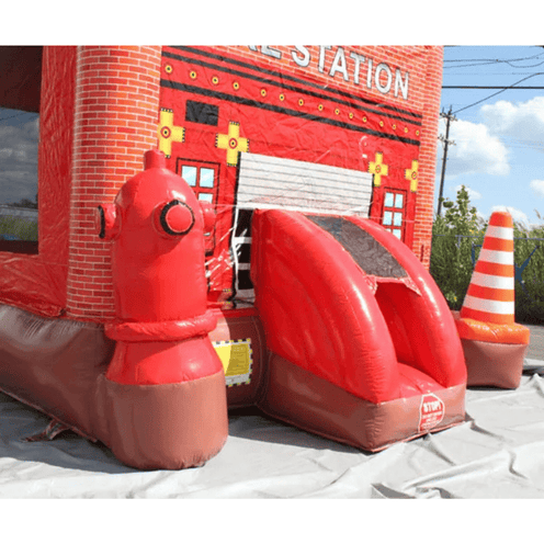 Firehouse bounce house showing detailed red brick fire station building with garage door and fire hydrant